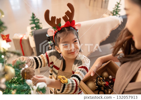 Festive Moments. Child decorating Christmas tree with joy and excitement. Festive Moments. Child decorating Christmas tree with joy and excitement. 132057913
