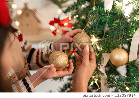 Christmas Decorations. Child and mother selecting ornaments for the tree. 132057914