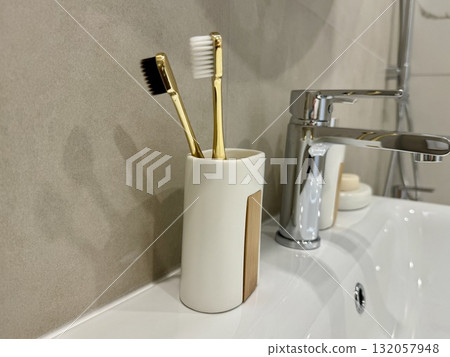 Toothbrushes in a glass in the bathroom in bright colors 132057948