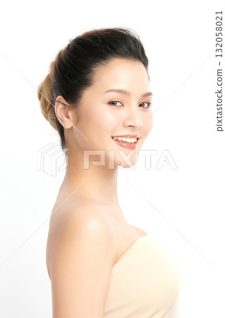 A beautiful young Asian woman with clean, fresh skin against a white background. Skincare, facial treatment, cosmetology, beauty, and spa. An elegant portrait of an Asian woman. 132058021