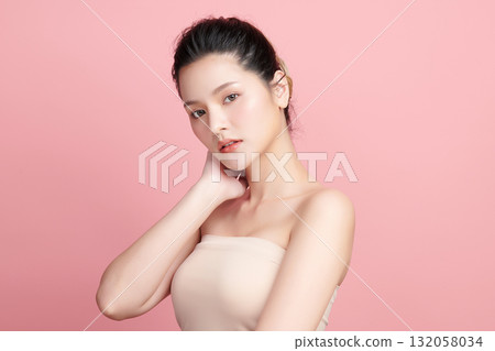 A beautiful young Asian woman with clean, fresh skin against a pink background. Skincare, facial treatment, cosmetology, beauty, and spa. An elegant portrait of an Asian woman. A beautiful young Asian woman with clean, fresh skin against a pink background. Skincare, facial treatment, cosmetology, beauty, and spa. An elegant portrait of an Asian woman. 132058034