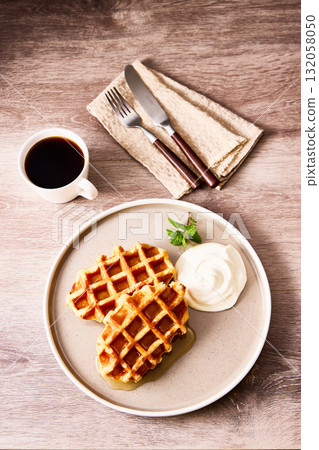 Tea time with freshly baked waffles and whipped cream Tea time with freshly baked waffles and whipped cream 132058050