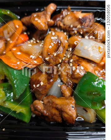 Delicious chicken stir fry with sesame seeds and vegetables in takeout box lunch fast food Delicious chicken stir fry with sesame seeds and vegetables in takeout box lunch fast food 132058056