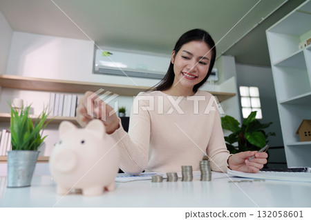 Financial Responsibility. Woman depositing coins into a piggy bank. Financial Responsibility. Woman depositing coins into a piggy bank. 132058601