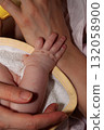 Tender Baby Hand Resting on Adult Arm During Gentle Bonding Moment of Care 132058900