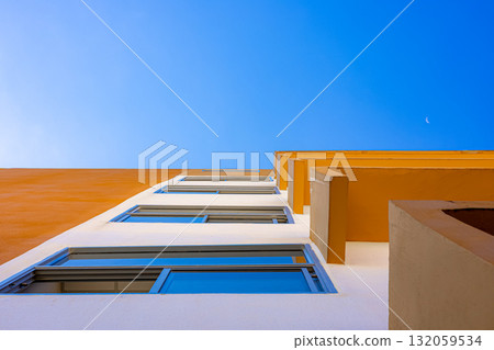 Modern yellow and white building with blue sky minimal architecture perspective 132059534