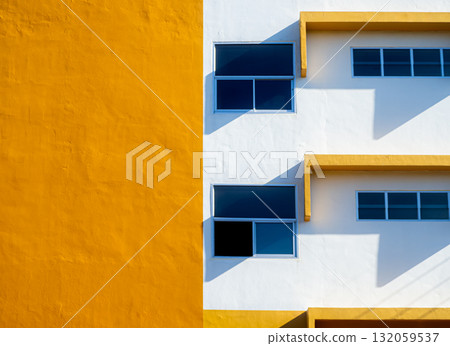 Modern yellow and white building facade with blue windows minimal architecture 132059537