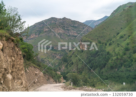 A mountain range with a dirt road leading up to it 132059730