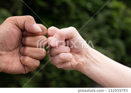two people putting fists together two people putting fists together 132059745
