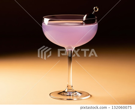 Refined violet drink in coupe glass with glowing highlight and cherry garnish reflecting light on sleek bar surface 132060075