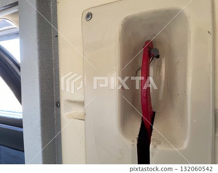 Red emergency handle on vehicle interior panel 132060542