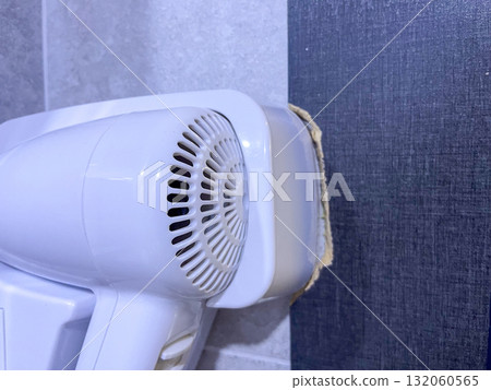 Wall-mounted white hair dryer in bathroom Wall-mounted white hair dryer in bathroom 132060565
