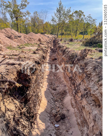 Deep trench dug in sandy soil outdoors Deep trench dug in sandy soil outdoors 132060585