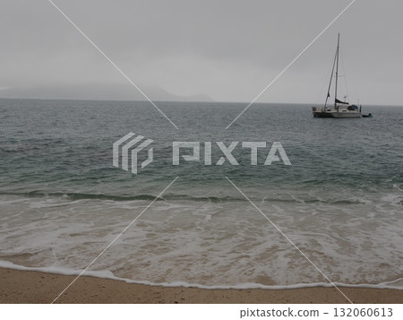 Fitzroy Island – A yacht floating on the cloudy sea and the island in the distance 132060613
