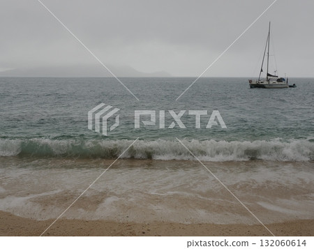 菲茨羅伊島—一艘白色遊艇漂浮在雲霧繚繞的海面上,遠處是島嶼 菲茨羅伊島—一艘白色遊艇漂浮在雲霧繚繞的海面上,遠處是島嶼 132060614