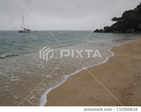 Fitzroy Island – a tranquil beach with rocky outcrops and yachts 132060616