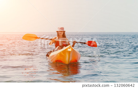 Kayaking Woman Sea Sunset - Kayaking during a beautiful sunset on the sea. 132060642