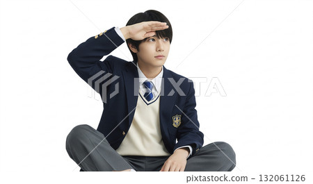 A high school boy peering into the distance with his palm resting on his eyebrows 132061126