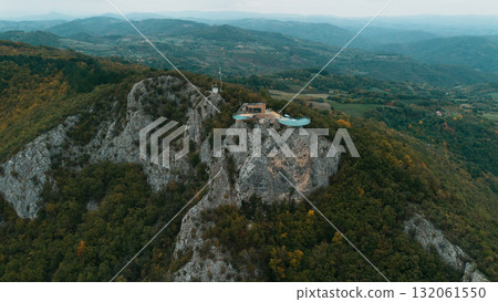 Modern glass observation deck on Mount Kablar offers breathtaking panoramic views of the Western Morava valley and lush Serbian mountains. Aerial view from drone 132061550