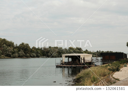 Floating restaurant barge on the Danube River with trees on the opposite bank in Belgrade Floating restaurant barge on the Danube River with trees on the opposite bank in Belgrade 132061581