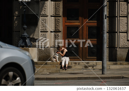 Woman sitting on stairs with Border Collie puppy in front of Belgrade government building. Travel with pet concept. Woman sitting on stairs with Border Collie puppy in front of Belgrade government building. Travel with pet concept. 132061637