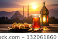 Celebrating Ramadan with tea and baklava while enjoying a beautiful sunset and lantern glow 132061860