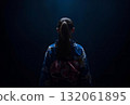 一位身著正式服裝的年輕女子背對著黑暗的空間 132061895