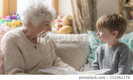 Grandmother reading a picture book to young boy on cozy sofa, showcasing multigenerational family life and emotional connection in a warm setting Grandmother reading a picture book to young boy on cozy sofa, showcasing multigenerational family life and emotional connection in a warm setting 132062179