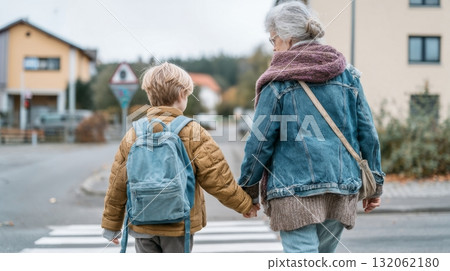 Grandmother and grandson walking hand in hand across a crosswalk, showcasing multigenerational family life and emotional connection in a suburban setting Grandmother and grandson walking hand in hand across a crosswalk, showcasing multigenerational family life and emotional connection in a suburban setting 132062180