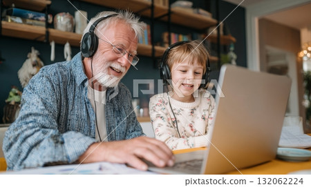Grandparent and grandchild enjoying quality time together while editing a video on a laptop, showcasing a multigenerational bond and emotional connection Grandparent and grandchild enjoying quality time together while editing a video on a laptop, showcasing a multigenerational bond and emotional connection 132062224