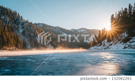 Snowy mountain landscape at dawn with long shadows and sunlight illuminating the frozen lake, capturing the essence of winter solstice traditions 132062261