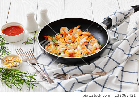 rosemary and garlic seared shrimps in a skillet rosemary and garlic seared shrimps in a skillet 132062421