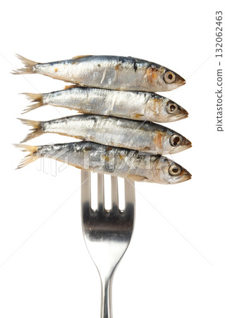 Four fresh, whole sardines stacked on a silver fork, healthy seafood ingredient isolated on a transparent background 132062463