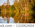 Tranquil Reflections: House and Trees Mirrored in River 132062604