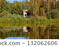 Tranquil Reflections: House and Trees Mirrored in River 132062606