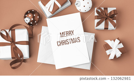 Merry christmas background, paper holiday greeting card with gift boxes and xmas ball on mocha mousse color background 132062981