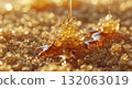 An extreme macro close-up photograph showcasing the complex crystallized texture of honey, illuminated by warm, intense golden hour light.  132063019