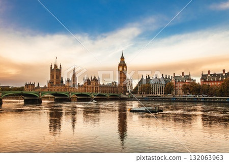 Palace of Westminster and Elizabeth Tower reflecting in River Thames under blue and golden sky in London Palace of Westminster and Elizabeth Tower reflecting in River Thames under blue and golden sky in London 132063963