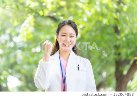 戶外穿白大褂的女人，新鮮的綠色植物，拳頭泵 132064898