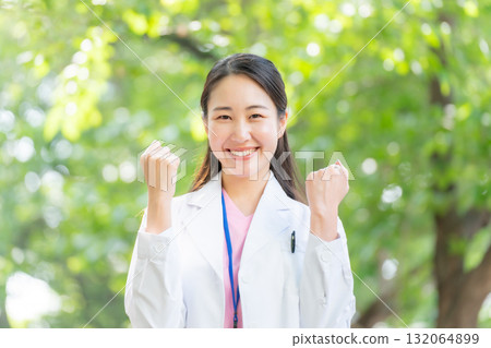 戶外穿白大褂的女人,新鮮的綠色植物,拳頭泵 戶外穿白大褂的女人,新鮮的綠色植物,拳頭泵 132064899