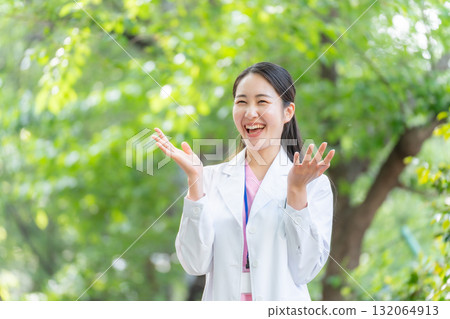 戶外穿白大褂的女人，新鮮的綠色植物，揮手 132064913