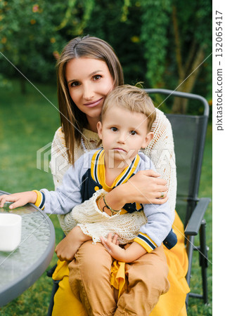 Loving Mother Holding Child In Garden Chair 132065417
