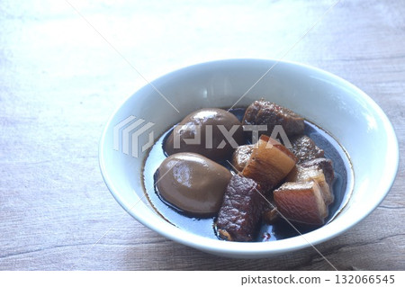 boiled egg with fat pork and fried dice tofu in herb brown soup on bowl  132066545