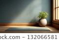 Serene yoga mat lies on wooden floor beside potted plant, bathed in soft natural light from window 132066581