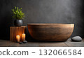 Wooden bathtub in serene spa setting with candles and potted plant creates calming atmosphere 132066584