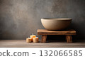 Serene spa setting with stone bowl on wooden stand and lit candles creates calming atmosphere 132066585