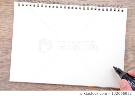 Hand holding a notebook and a black permanent marker 132066932
