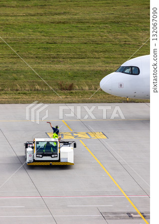 Modern regional jet aircraft towed by ground vehicle on airport taxiway tarmac under sunlight. Engine cockpit clearly visible crew performs technical operations before next scheduled flight airport Modern regional jet aircraft towed by ground vehicle on airport taxiway tarmac under sunlight. Engine cockpit clearly visible crew performs technical operations before next scheduled flight airport 132067090