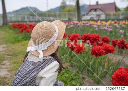 A girl looking at a tulip 132067587