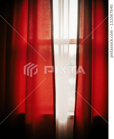 Sunlight streams through translucent red curtains, creating a warm and welcoming ambiance in a room. The soft fabric adds color and charm, illuminating the space softly Generative AI 132067640